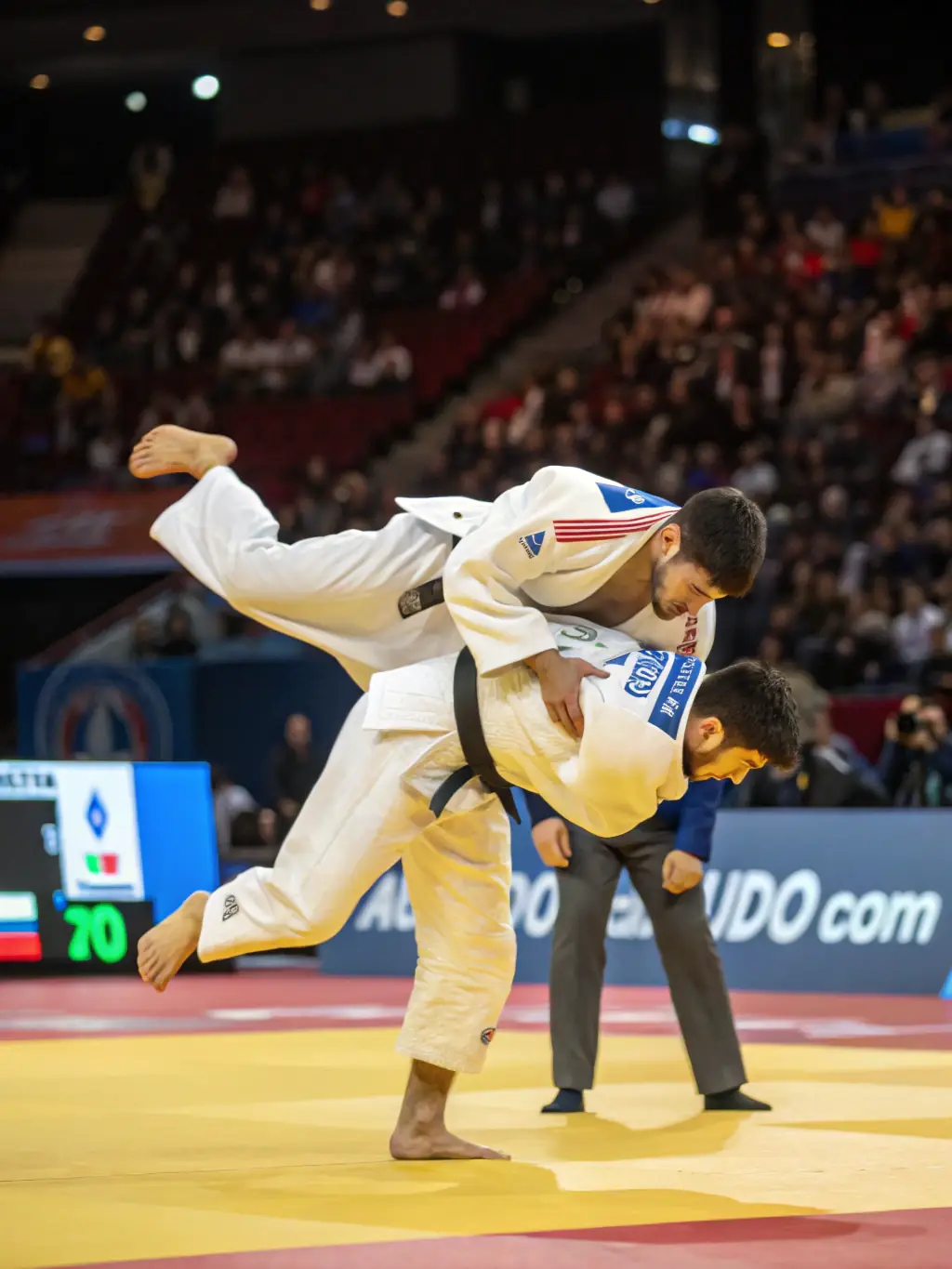 A dynamic photo of Judo Club Devoluy members engaged in a judo sparring session, showcasing their agility and technique, set against the backdrop of the club's training facility.